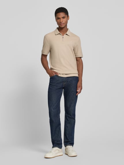 Männermodel trägt Regular Fit Poloshirt mit Strukturmuster Modell 'Tibaris' von JOOP! COLLECTION, beige, Label-Stitching, Polokragen, Reißverschluss, Rückenlänge bei Größe M 70 cm, Ganzkörperansicht von vorne.