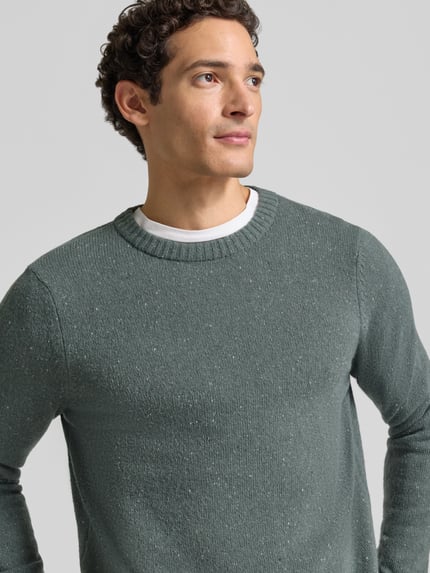 Männermodel trägt Pullover mit Tweed-Struktur von MARC O'POLO in melierter Strickoptik, Rundhalsausschnitt, Nahaufnahme Oberkörper