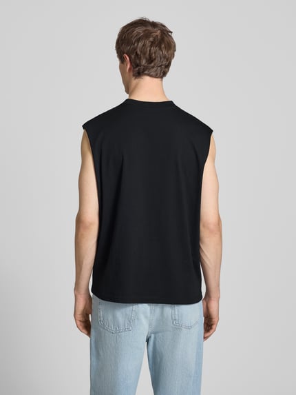 Männermodel trägt Muskelshirt mit Logo und Rundhalsausschnitt von REVIEW, Reine Baumwolle, Regular-Fit, Rückenlänge 68 cm, Ganzkörperansicht Rückansicht.