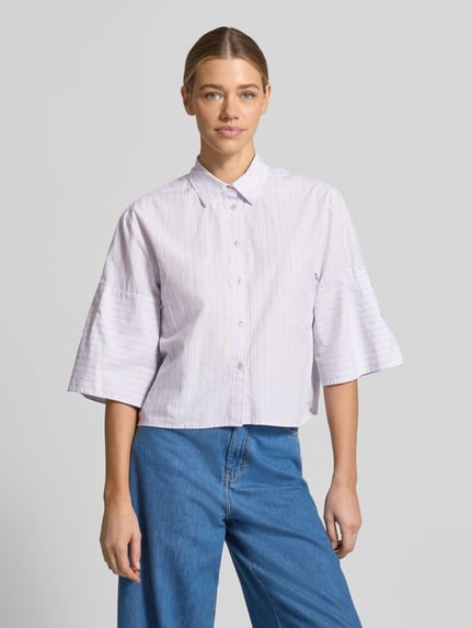 Frauenmodel trägt Relaxed Fit Hemdbluse mit Hemdblusenkragen von Emily Van den Bergh aus reiner Baumwolle, feine Streifen in Pastelltönen, durchgehende Knopfleiste, 3/4-Arm, kombiniert mit blauer Jeans, Ganzkörperansicht von vorne.