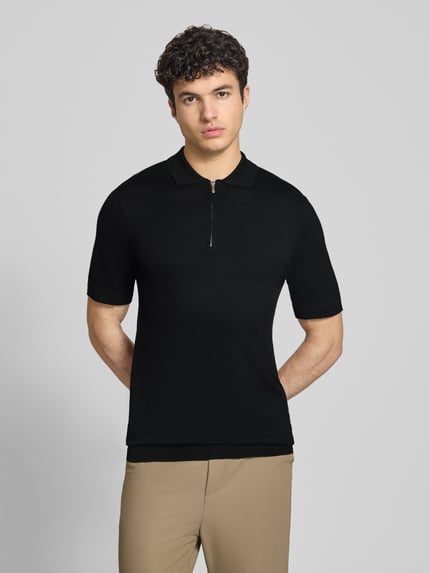 Męski model nosi Regular Fit Poloshirt aus Viskose-Mix Modell 'WYLER' od Only & Sons, czarny, krótkie rękawy, dzianina, widok z przodu, ujęcie całej sylwetki.