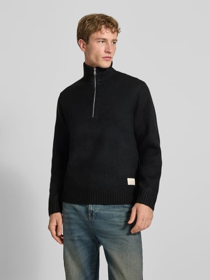 Männermodel trägt Relaxed Fit Strickpullover aus elastischem Woll-Mix von JACK & JONES, dunkle Farbe, Troyer-Kragen, Nahaufnahme Oberkörper.