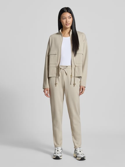 Vrouwenmodel draagt Regular fit sweatjack uit katoenmix van JOOP! in beige, met zakken vooraan, gladde textuur, volledige lichaamsvooraanzicht.