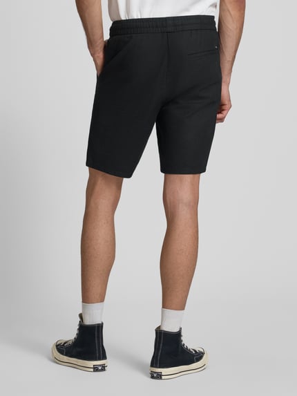 Männermodel trägt Regular Fit Bermudas aus Baumwoll-Leinen-Mix Modell 'LINUS' von Only & Sons, unifarben, elastischer Bund, Rückansicht Ganzkörperansicht.