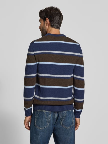 Männermodel trägt Strickpullover aus Woll-Mix im Allover-Look von MCNEAL mit blauen und braunen Streifen, Ganzkörperansicht Rückansicht. Slim Fit, Rundhalsausschnitt, Rückenlänge 68 cm, Ärmellänge 68 cm.