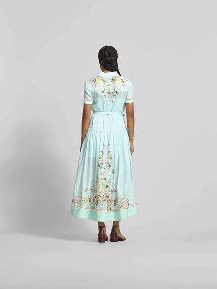 Vrouwenmodel draagt Midikleid met Seide-Anteil van Self-Portrait in lichtblauw met bloemenprint, katoenmix met zijde, getailleerd, borstzakken, riem, met korte mouwen, totale lengte maat S 134 cm, borstwijdte 46 cm, mouwlengte 20 cm, geheel achteraanzicht.