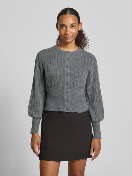 Frauenmodel trägt Strickjacke mit Rundhalsausschnitt Modell 'NOELLA' von NOISY MAY®, grau, Rippstruktur, Knopfleiste, Slim Fit, Ganzkörperansicht von vorne.