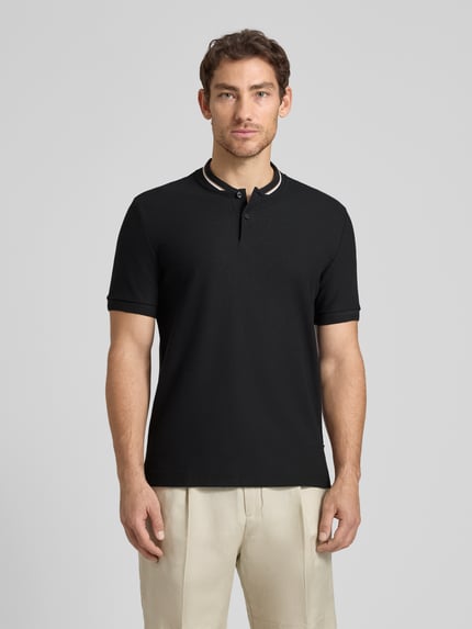 Männermodel trägt Regular Fit Poloshirt aus einer Baumwolle C-PRATT40 von BOSS, Optik: Unifarben, Piqué, Ganzkörperansicht von vorne.