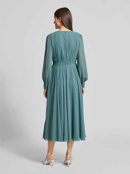 Frauenmodel trägt Regular Fit Midikleid mit Taillenband von Christian Berg Cocktail in Türkis, Chiffon, taillierte Passform, Ganzkörperansicht Rückansicht.