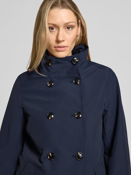 Frauenmodel trägt Regular Fit Jacke mit Stehkragen von Christian Berg Woman Selection aus Material-Mix mit Baumwoll-Anteil, Eingrifftaschen, dunkelblau, Knopfleiste, Nahaufnahme Oberkörper.