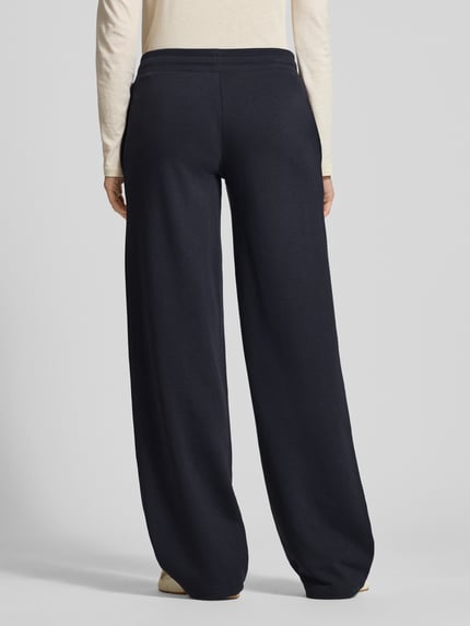 Vrouwenmodel draagt Wide Fit Sweatpants met viscose van Review in donkerblauw, mix van katoen en viscose, elastische band met tunnelkoord, binnenbeenlengte maat S 89 cm, wide fit design, geheel zichtbaar van achteren