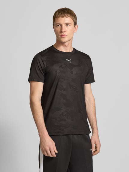 Männermodel trägt T-Shirt mit Label-Detail Modell 'CLOUDSPUN' von PUMA PERFORMANCE, Schwarz, Elastischer-Material-Mix, Gerader-Schnitt, Rundhalsausschnitt, Label-Detail, Rückenlänge 63 cm bei Größe M, Ganzkörperansicht von vorne.