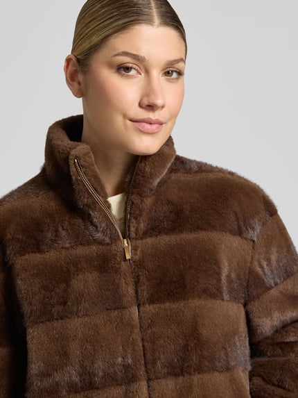 Kobieta modelka ma na sobie Regular Fit Jacke aus Kunstfell od PETITE M., brązowe sztuczne futro, Pikowanie, Stójka, zamek błyskawiczny, Szerokość ramion w rozmiarze 36: 42 cm, Szerokość klatki piersiowej w rozmiarze 36: 56 cm, Długość tyłu w rozmiarze 36: 57 cm, Długość rękawów w rozmiarze 36: 57 cm, zbliżenie na górną część ciała.