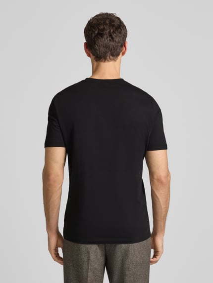 Mężczyzna nosi T-Shirt aus Baumwolle Modell 'Thompson' von BOSS, czarne, prosta forma, delikatny logo print, zdjęcie całej sylwetki z tyłu.