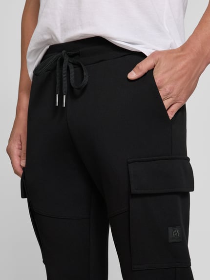 Männermodel trägt Regular Fit Sweatpants mit Cargotaschen von Antony Morato in Schwarz, Baumwoll-Mix, Nahaufnahme Oberschenkel.