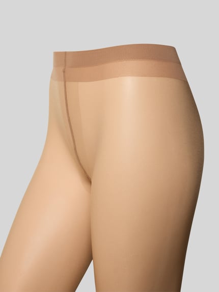 Vrouwenmodel draagt Transparante panty met nauwsluitende pasvorm, elastische band, SHELINA 12 DEN van Falke, detailopname heupen.