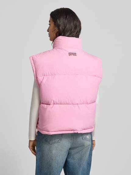 Vrouwenmodel draagt roze Steppweste met Stehkragen Modell 'ROFY' van American Vintage, rechte snit, rugaanzicht, detailopname.