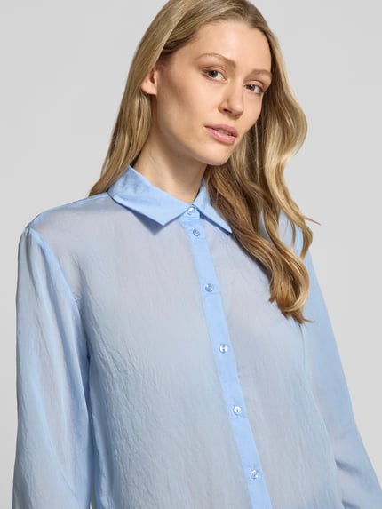 Vrouwenmodel draagt Relaxed Fit Hemdbluse aus Lyocell-Mix van Stefanel in lichtblauw, semi-transparant, met overhemdkraag, knoopsluiting, met lange mouwen, ruglengte maat 36: 70 cm, mouwlengte maat 36: 58 cm, nahaufnahme bovenlichaam.