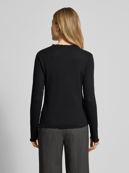 Vrouwenmodel draagt Slim Fit Langarmshirt met Viskose-Anteil van s.Oliver RED LABEL in effen zwart, gebreide look, ribtricot, met labelstitching, hooggesloten hals, lange mouwen met frill mouwboord en rompzoom; Ganzkörperansicht Rückansicht.
