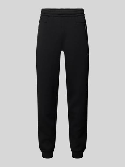 Produktfoto, schwarze Sweatpants mit gerader Passform, elastischem Bund und Reißverschlusstaschen, Modell 'TRAIN PREMIUM SHIELD' von EA7 Emporio Armani, Material-Mix mit Viskose-Anteil, gerippte Abschlüsse, Innenbeinlänge 78 cm