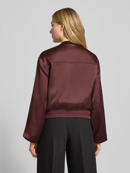 Frauenmodel trägt Blouson mit Reißverschluss Modell 'Jupita' von OPUS in Bordeaux, gerade Form, glatte Textur, Ganzkörperansicht Rückansicht.