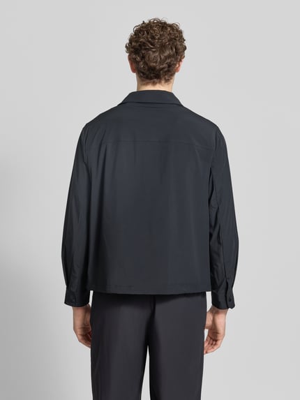 Männermodel trägt Blouson mit Kentkragen und Brusttasche von ARMANI EXCHANGE, schwarz, Material-Mix, Regular Fit; Ganzkörperansicht Rückansicht.