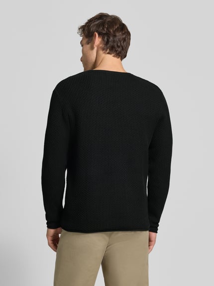 Männermodel trägt Strickpullover mit Struktur-Muster Modell 'BLUMASON' von JACK & JONES in Schwarz aus reiner Baumwolle, Rückansicht, Ganzkörperansicht Rückansicht.