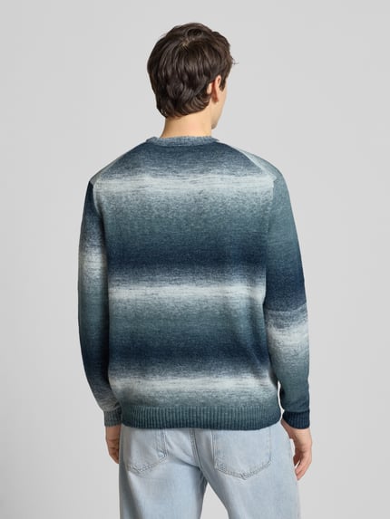 Männermodel trägt Regular Fit Strickpullover mit Baumwoll-Anteil Modell 'BERTIL' von Only & Sons in Blau-Grau Allover-Muster, Ganzkörperansicht Rückansicht.