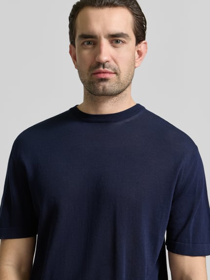 Männermodel trägt T-Shirt mit geripptem Rundhalsausschnitt von CRUNA, reine Baumwolle, Regular Fit, dunkelblau, Nahaufnahme Oberkörper.