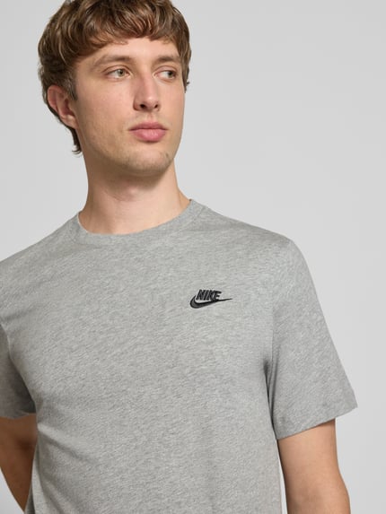 Männermodel trägt T-Shirt mit Label-Stitching von Nike in Grau, Reine Baumwolle, Regular-Fit, Rundhalsausschnitt, Nahaufnahme Oberkörper. Rückenlänge bei Größe M: 73 cm.