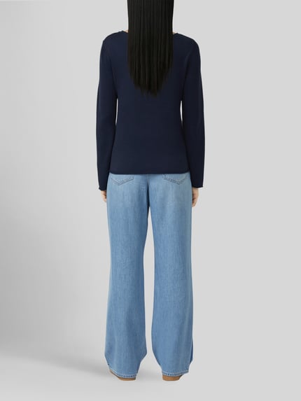 Frauenmodel trägt Regular Fit Pullover aus Baumwoll-Viskose-Mix von s.Oliver RED LABEL in Dunkelblau, kombiniert mit hellblauer Jeans, Ganzkörperansicht Rückansicht.