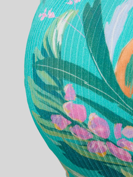 Frauenmodel trägt Bikini-Oberteil in Bandeau-Form Modell 'Sandra' von VENICE BEACH, türkis mit Allover-Blumenmuster, Detailaufnahme.