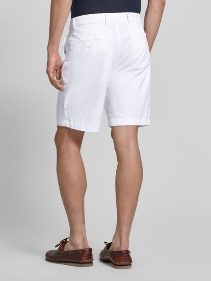 Männermodel trägt Chinoshorts aus Baumwoll-Mix Modell 'DOVER' von Tommy Hilfiger, Optik: Unifarben, Passform: Regular-Fit, Ganzkörperansicht Rückansicht.