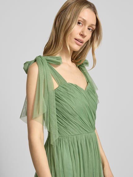 Vrouwenmodel draagt knielange cocktailjurk im stufen-look van LACE & BEADS, mesh, A-lijn, draperingen, ruglengte maat S 104 cm, borstwijdte 40 cm, mesh textuur, effen groen, laagjeslook, nahaufnahme bovenlichaam.