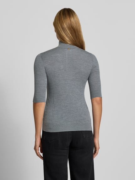 Vrouwenmodel draagt Slim Fit Longsleeve uit pure lamswol model 'Maglia Costine' van Liu Jo White, grijs, halve mouw, semitransparant, recht ribstructuur, staande kraag, ruglengte 58 cm, mouwlengte 34 cm, pure lamswol, semi-transparant design, volledig zichtbare rug, achteraanzicht.