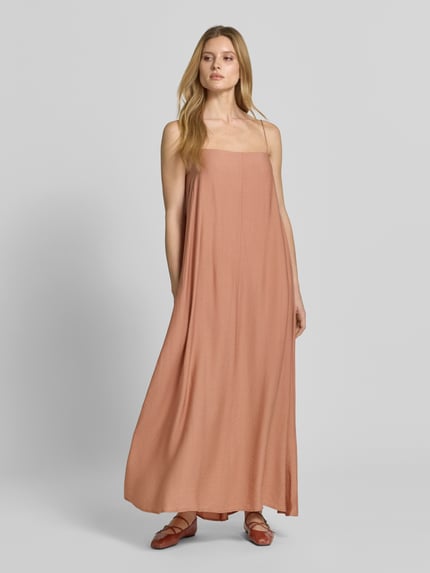 Frauenmodel trägt Maxikleid mit Spaghettiträgern und Karree-Ausschnitt von Style Icon Collection in Terrakotta, Lockerer-Schnitt, Ganzkörperansicht von vorne. Kontext: Schlüsselloch-Ausschnitt und Bindung hinten, Brustweite 27 cm bei Größe 36.