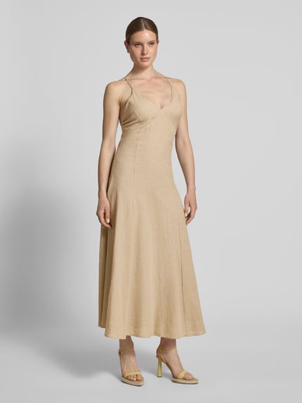 Frauenmodel trägt Regular Fit Leinenkleid mit Viskose-Anteil von Rinascimento in Beige, Maxilänge, Spaghetti-Träger, V-Ausschnitt, Ganzkörperansicht von vorne. Leinen-Mix mit Viskose-Anteil, Rückenlänge 142 cm, Brustweite 36 cm in Größe S.
