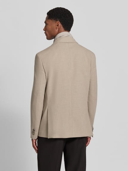 Männermodel trägt Slim Fit Sakko mit Viskose-Anteil von Manuel Ritz w kolorze beżowym, Mieszanka materiałów, Stójka z zamkiem błyskawicznym, kołnierz z połami, Brustasza, listwa guzikowa, boczne kieszenie z patką, Długość tyłu w rozmiarze 50: 78 cm, Szerokość w rozmiarze 50: 44 cm, Długość rękawów w rozmiarze 50: 68 cm, Ganzkörperansicht Rückansicht