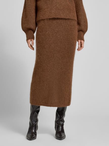 Frauenmodel trägt Pencil-Skirt in Midi-Länge aus Mohair-Mix - curated by Maja Weyhe von Style Icon Collection, braune Strick-Optik, gerader Schnitt, elastischer Bund, Damenmode, Nahaufnahme Unterkörper.