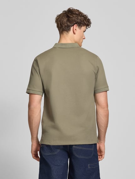 Męski model nosi Regular Fit Poloshirt mit Strukturmuster Modell 'AUSTIN' von Jack & Jones w kolorze khaki, tekstura bawełny, krój regular fit, widok całej sylwetki z tyłu, długość pleców w rozmiarze M: 69 cm.