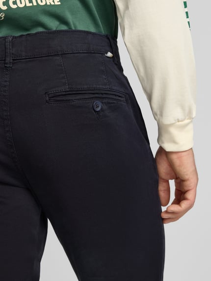 Männermodel trägt Straight Fit Chino mit Eingrifftaschen Modell 'Vance' von Jack & Jones aus Baumwoll-Mix, Detailaufnahme Gesäßtasche.