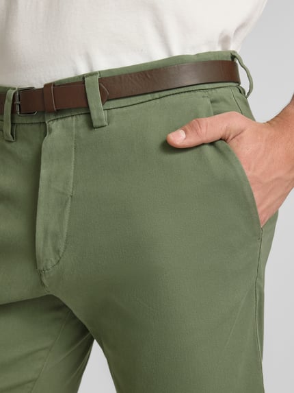 Männermodel trägt Straight Fit Shorts mit abnehmbarem Gürtel Modell 'Adam' von Jack & Jones in Grün, Baumwoll-Mix, Nahaufnahme Oberkörper, Herren Shorts, Eingriffstaschen, Knopf-Reißverschluss, Bundweite 40 cm Größe M, Innenbeinlänge 19 cm.