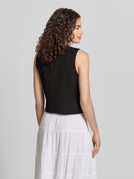 Vrouwenmodel draagt effen zwarte dames bodywarmer Shaped Fit met diepe V-hals, materiaalmix met viscose van Pieces, model 'KAMIL', volledige achteraanzicht