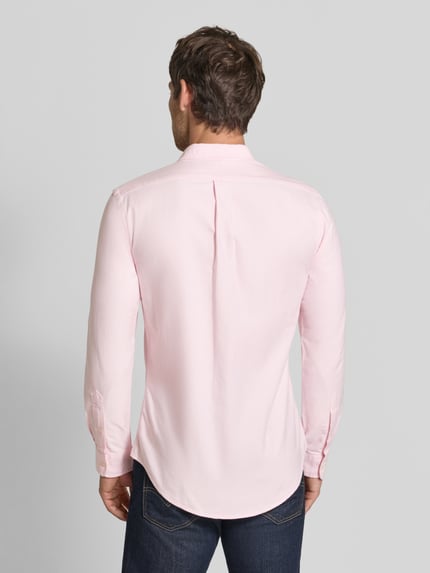 Männermodel trägt Slim Fit Freizeithemd aus reiner Baumwolle von Polo Ralph Lauren in hellrosa, glatte Textur, Ganzkörperansicht Rückansicht.