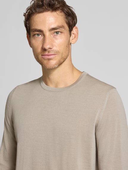 Männermodel trägt Strickpullover aus Schurwolle mit Rundhalsausschnitt von MAERZ Muenchen in Beige, Nahaufnahme Oberkörper, Regular Fit.