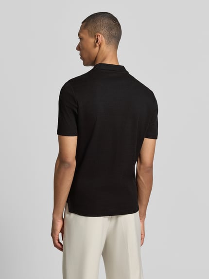 Männermodel trägt schwarzes Modern Fit Poloshirt mit Polokragen und Label-Detail von MARKUP aus reiner Baumwolle, Ganzkörperansicht Rückansicht. Rückenlänge bei Größe M: 70 cm.