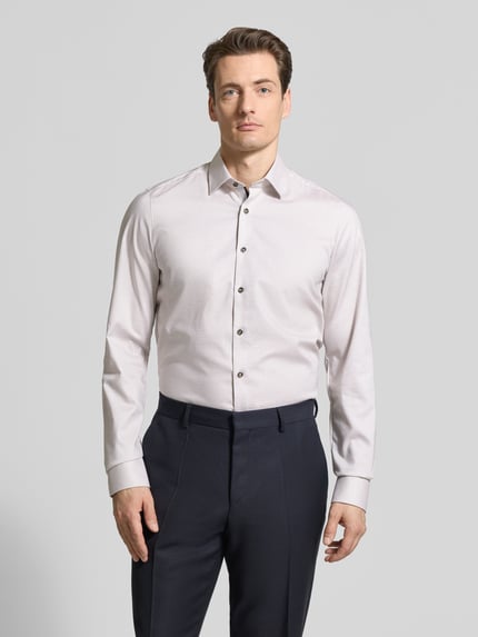 Männermodel trägt Body Fit Business-Hemd mit Kentkragen von OLYMP Level Five aus Baumwoll-Elasthan-Mix, Knopfleiste, Ganzkörperansicht von vorne. Rückenlänge 83 cm, Schulterbreite 44 cm, Ärmellänge 73 cm, dezente, glatte Textur, helles Hemd zu dunkler Hose.