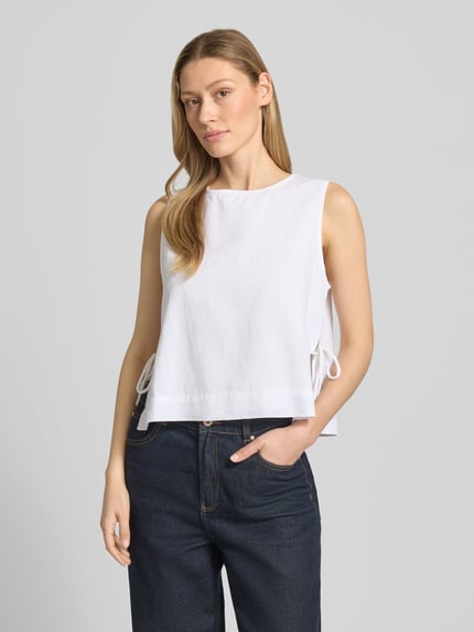 Modelka nosi białe blusenshirt z bawełny z bocznym sznurowaniem, krój luźny, rundy dekolt, Neo Noir Blusenshirt mit seitlicher Schnürung Modell 'Svetlana', długość tyłu w rozmiarze 36: 51 cm, widok całej sylwetki z przodu.