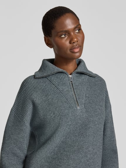 Frauenmodel trägt Pullover aus Wolle mit Troyerkragen von JAKE*S WOMAN CASUAL in Grau, grobe Strickoptik, Nahaufnahme Oberkörper.