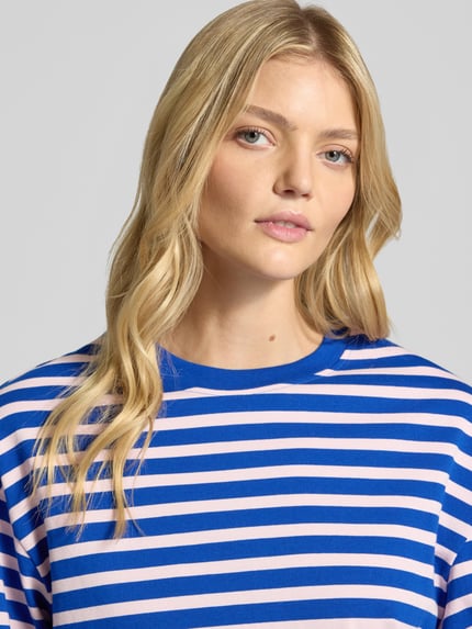 Frauenmodel trägt Longsleeve im Allover-Look mit Rundhalsausschnitt von Gina Tricot, blau-weiß gestreift, reine Baumwolle, Relaxed Fit, Nahaufnahme Oberkörper.